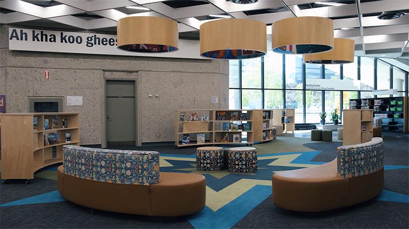 The Indigenous children's space at Millennium library with books, benches with Metis beadwork patterns and a star blanket carpet
