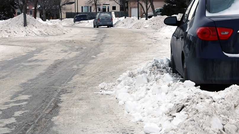 car surrounded by snow on street
