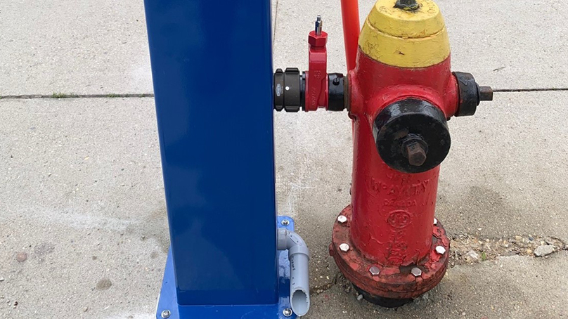 Side of blue hydration station with red fire hydrant.
