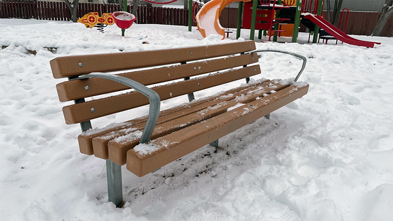Park bench in a snowy playground