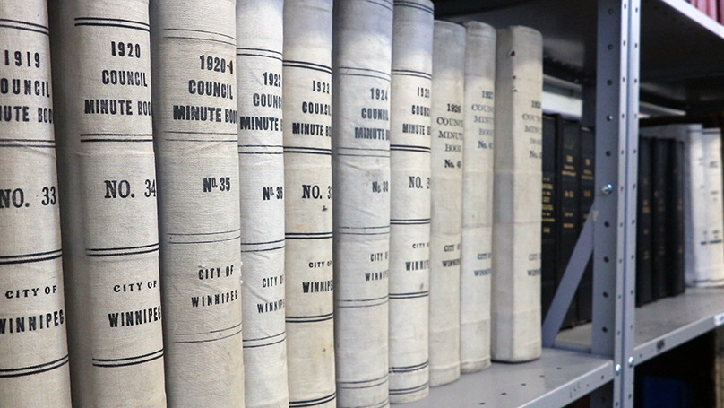 A close up of a shelf of books, the spines of the books show council minutes for years between 1920 and 1927 