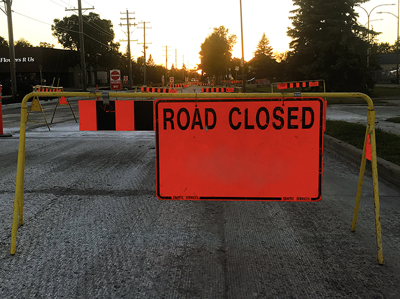 Barricade with road closed sign.