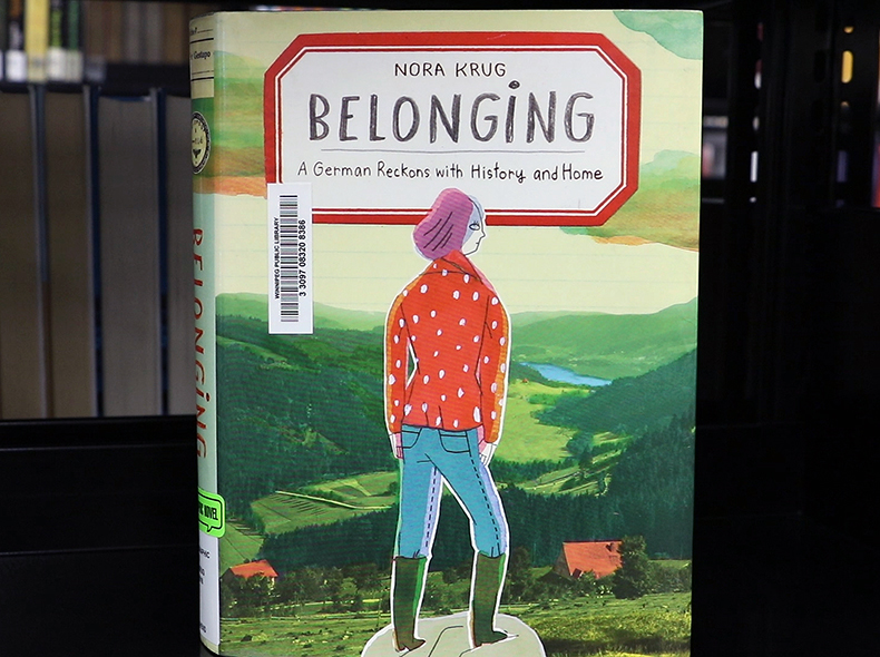  Cover of book Belonging with drawn women with orange jacket and blue jeans and pink beret-type hat