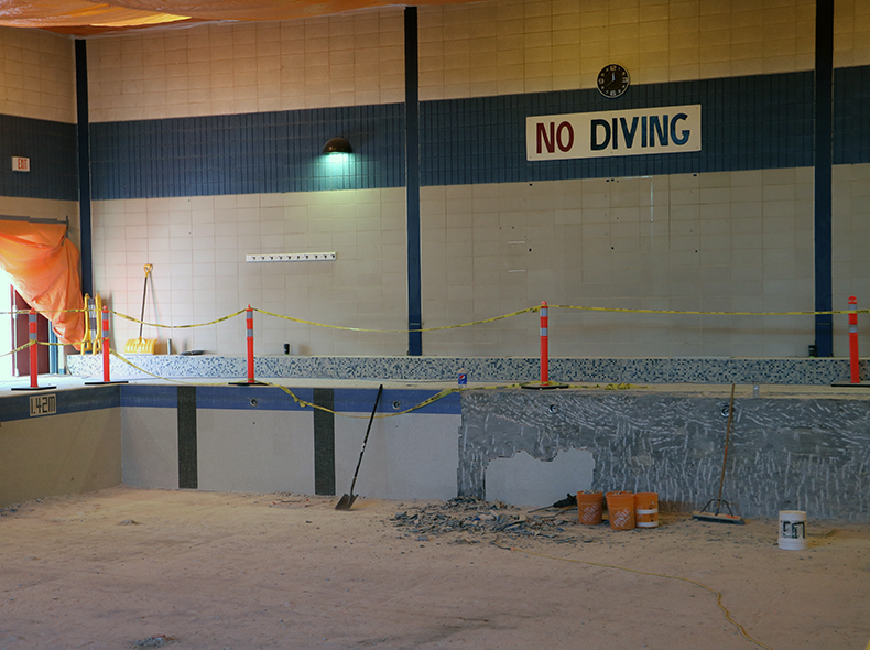 inside of empty pool with part of the tiles removed