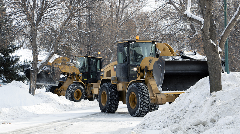 City trucks clearing snow on a residential street