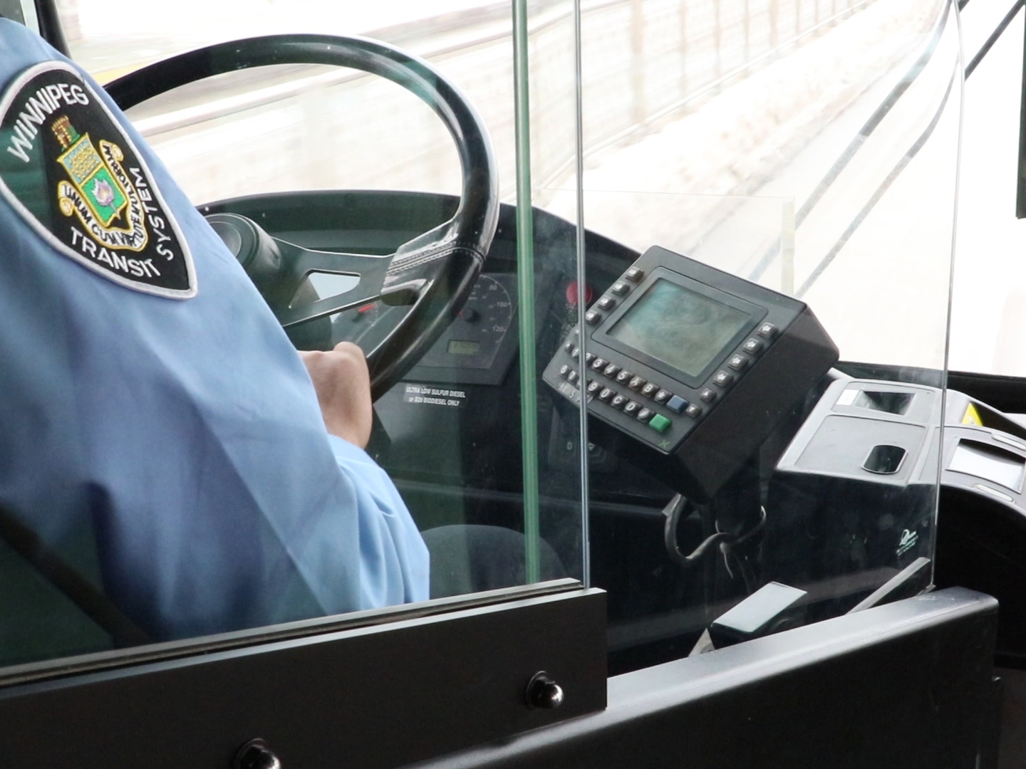 Winnipeg Transit driver behind a safety shield