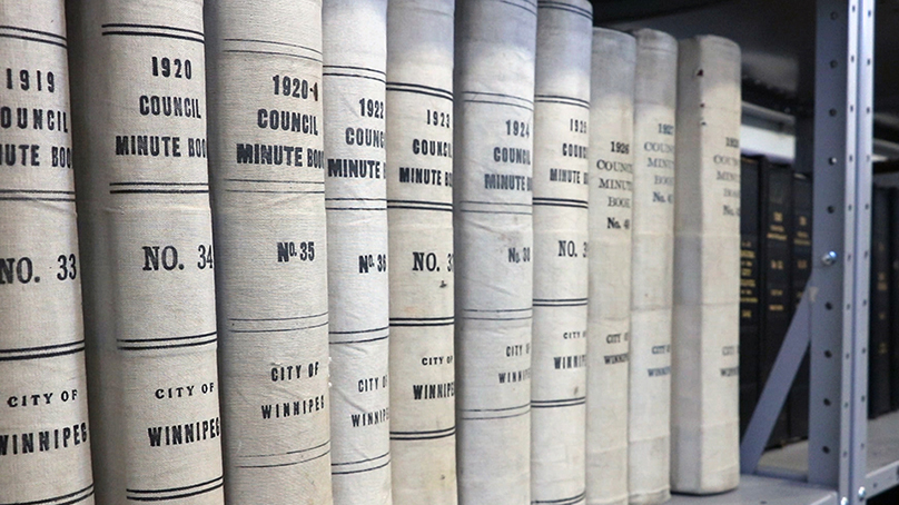 Archived City Council minutes, bound like books, sitting on a shelf.