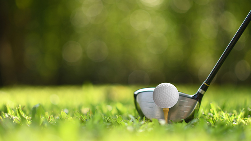 image of golf ball on tee with a golf club
