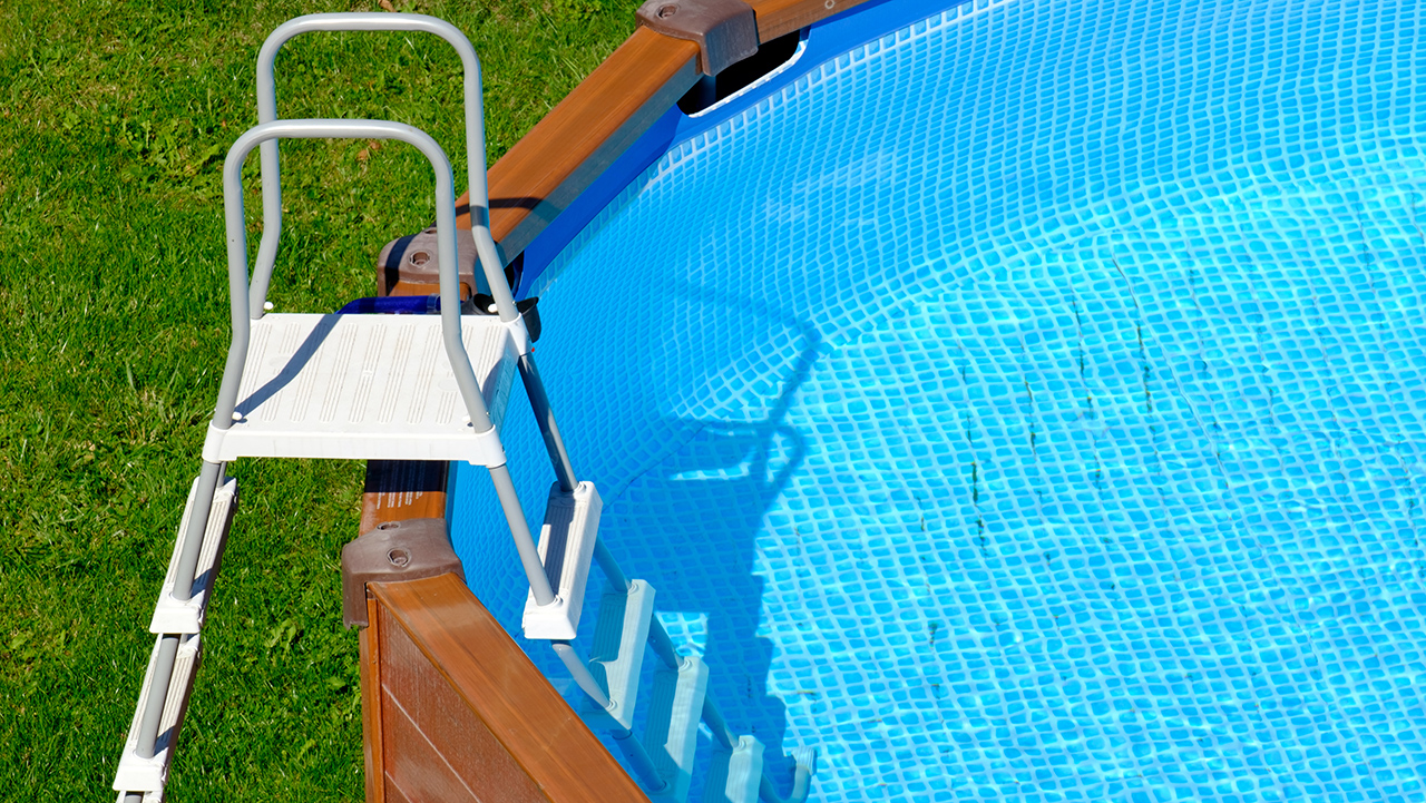 An outdoor pool with stairs to enter and exit.