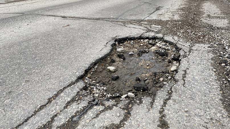 An unfilled pothole in a road.
