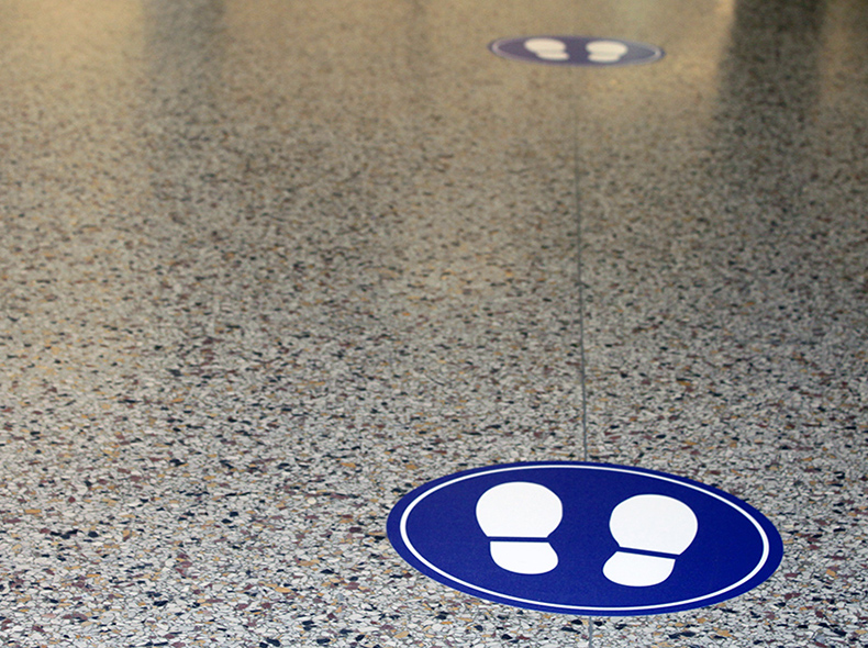 Two circular blue floor decals with white footprints