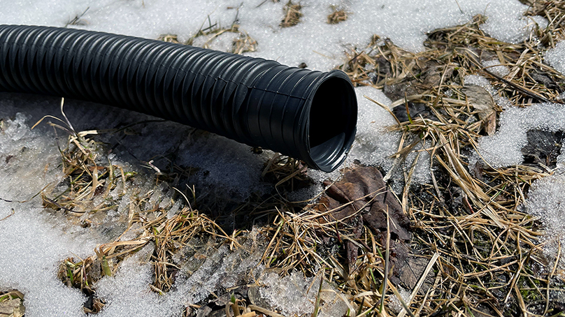 Black sump pump hose in yard