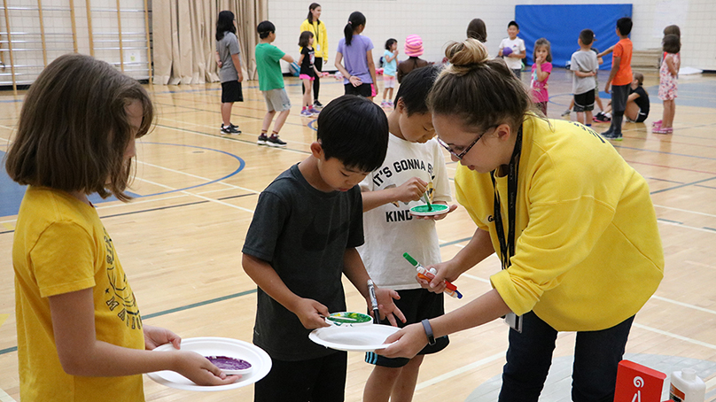 Worker helping children with a craft project