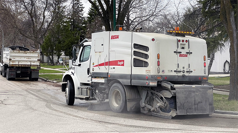 Street sweeper cleaning a street in spring