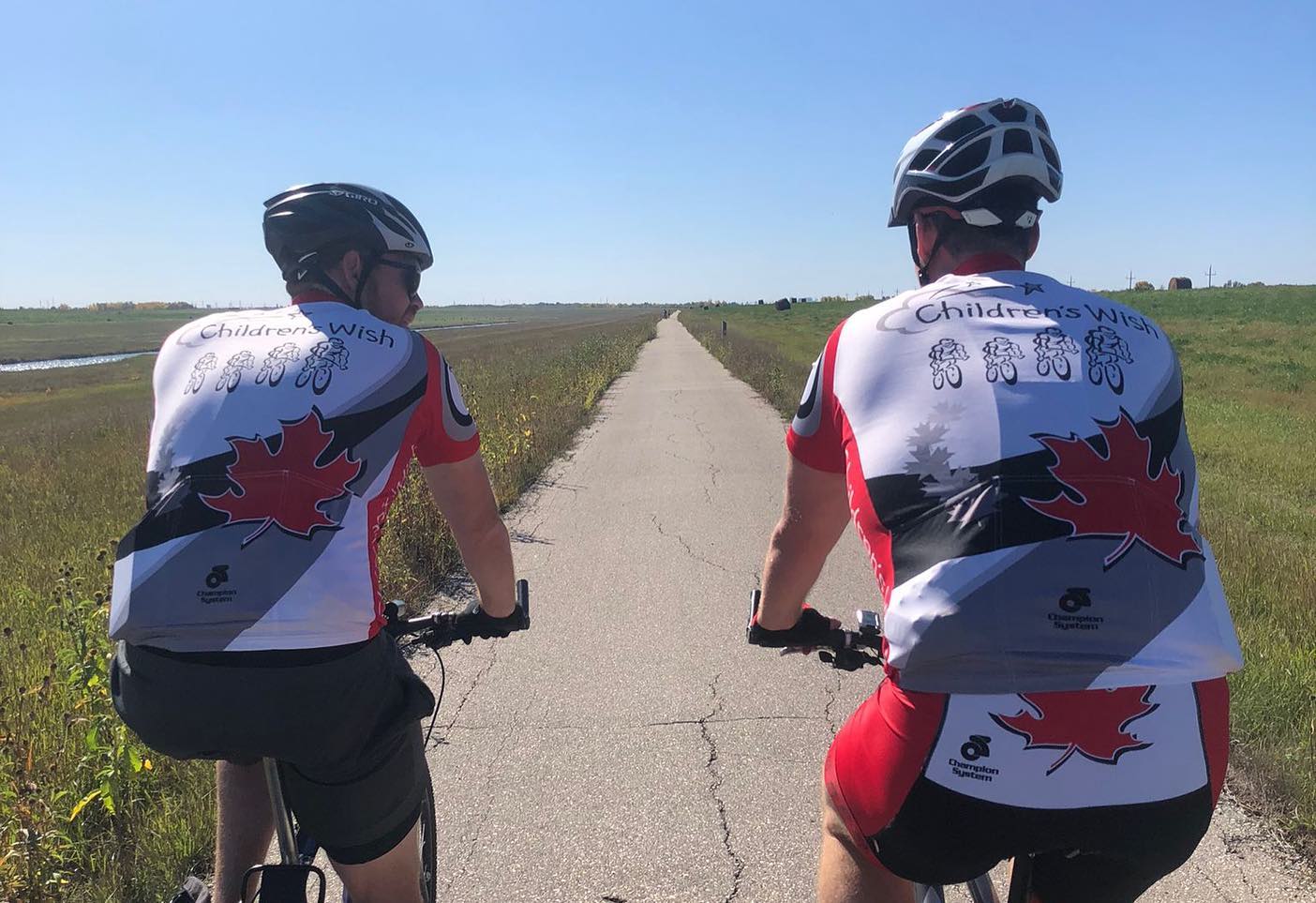Two cyclists are seen on the open road.