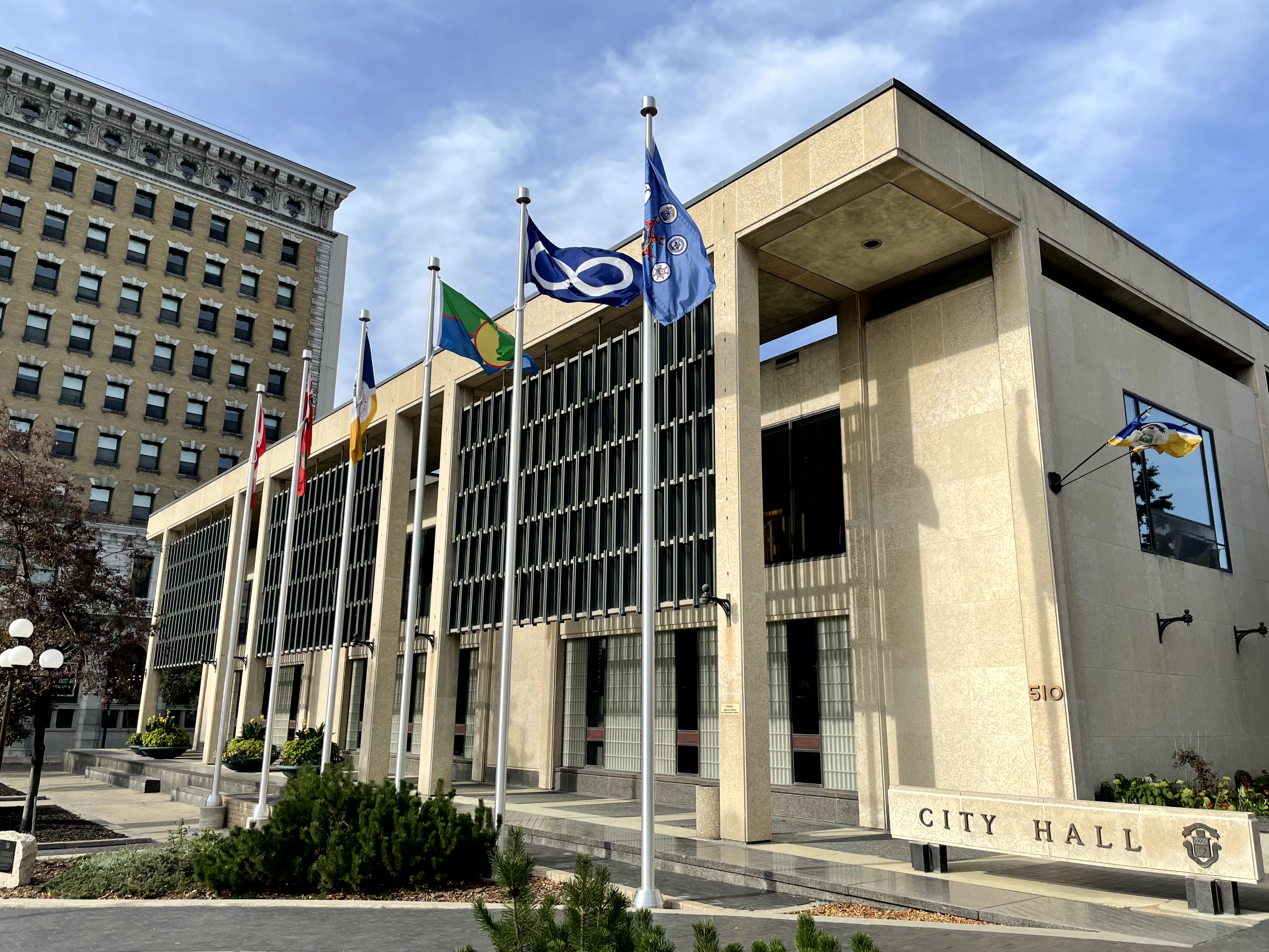 Flags fly around Winnipeg City Hall Council Building.