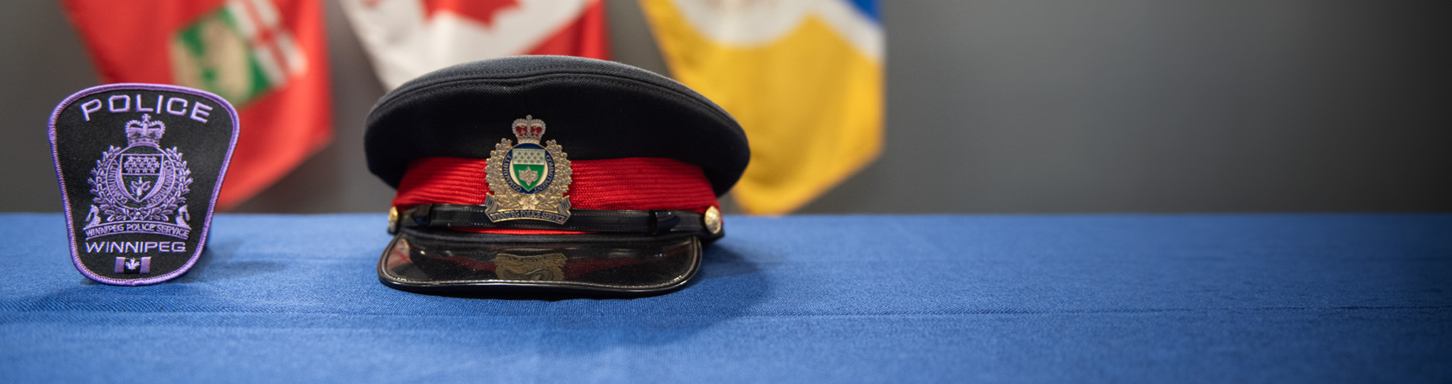 Police badge and police cap sitting on table