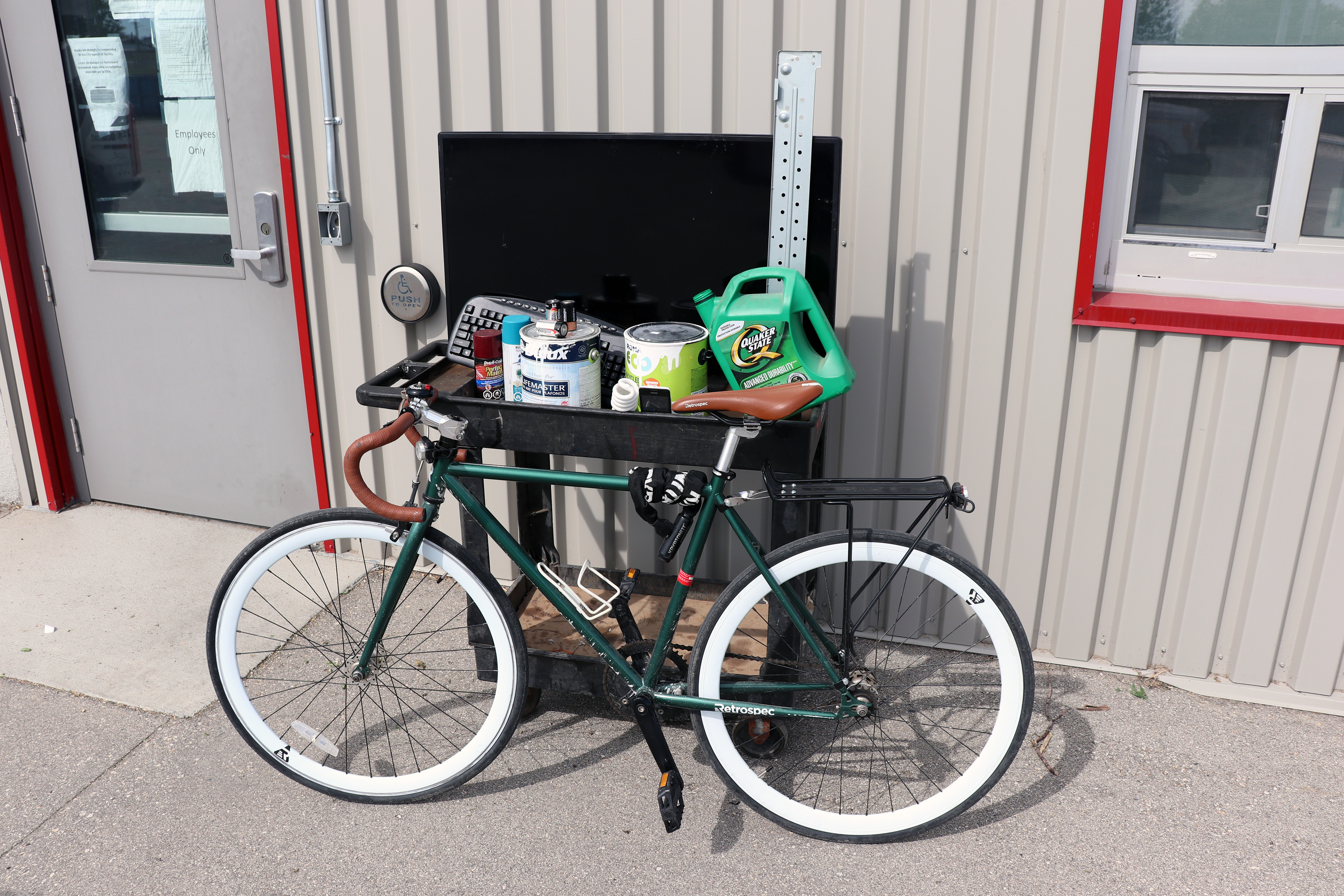 A bicycle and some hazardous items are pictured outside of a Winnipeg 4R depot,