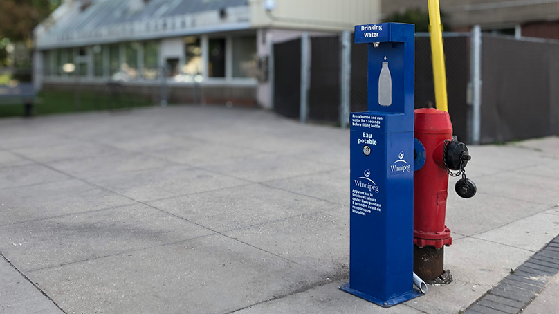 Drinking water station on sidewalk attached to fire hydrant