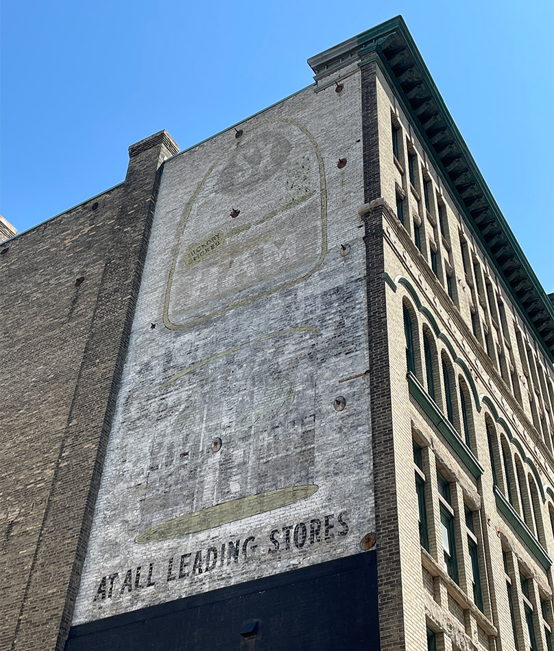 This historic painted ‘ghost’ sign on the Swiss Building has been left to weather naturally and is a character-defining element of the building. 
