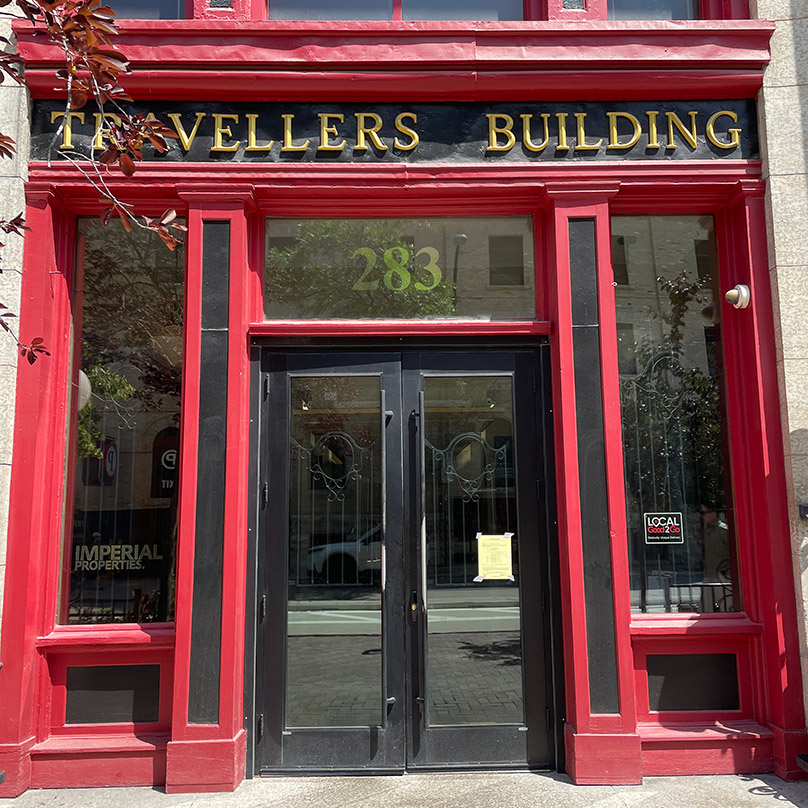 Building identification signage at the Travellers Building is located within the original storefront signage band. Rare earth magnets hold the letters in place to avoid penetrations through the historic metal cornice. 