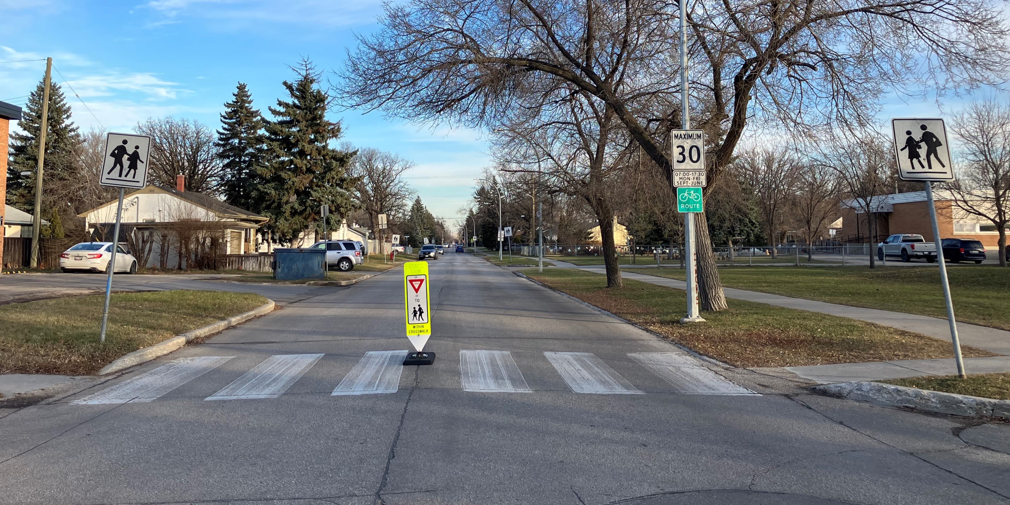In-street school crosswalk sign in the middle of the road
