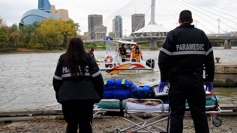 Paramedics waiting near river for water rescue boat
