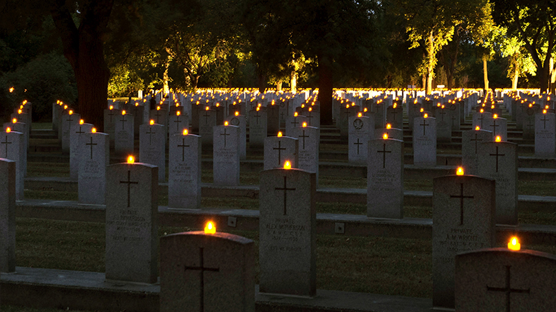 Cemetery with candles lit on each grave headstone