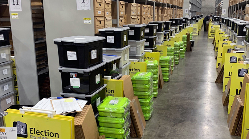 Boxes and supplies lined up down a storage warehouse aisle