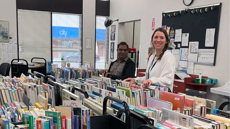 Two library workers sorting books