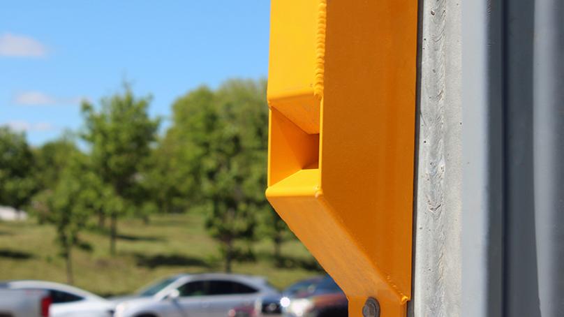 A yellow accessible pedestrian sound device