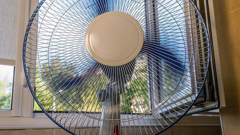 Running fan in front of an open window.
