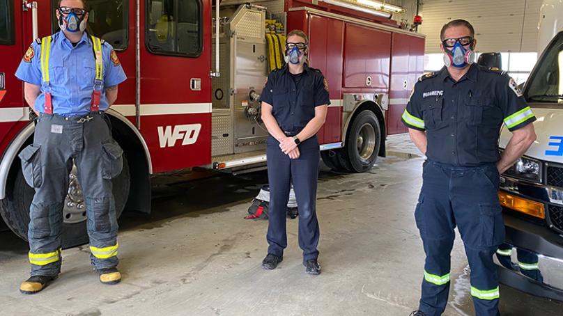 WFPS employees with COVID masks standing in front of emergency vehicles 