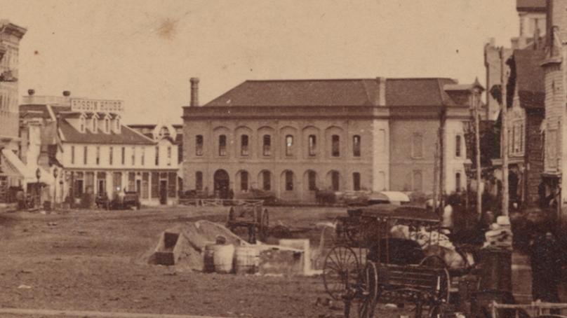 A sepia-toned photo of Winnipeg circa 1979 pictures an administrative building surrounded by various carts and buggies