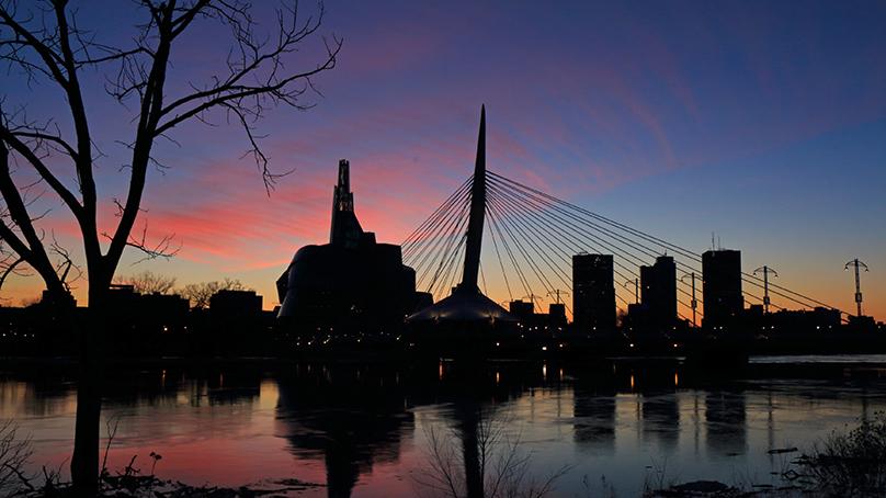 Silhouette of the Esplanade Riel against a colourful sunset