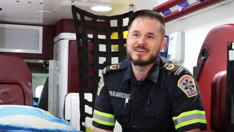 A paramedic sits in the back of an ambulance