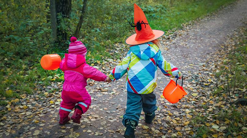 Two toddlers dressed for the weather to trick or treat during Halloween.