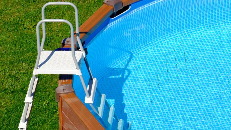 An outdoor pool with stairs to enter and exit.