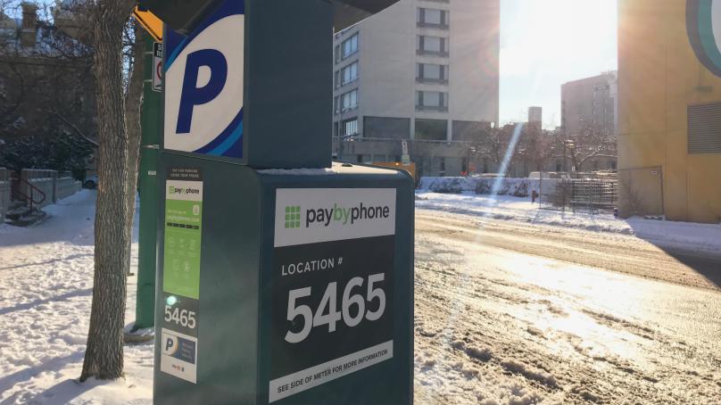 Parking meter next to a snow covered road