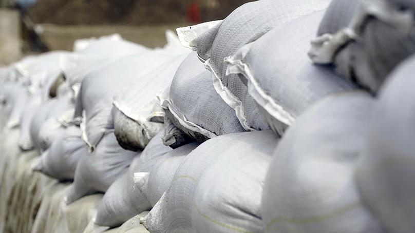 White sandbags piled together to prevent flooding