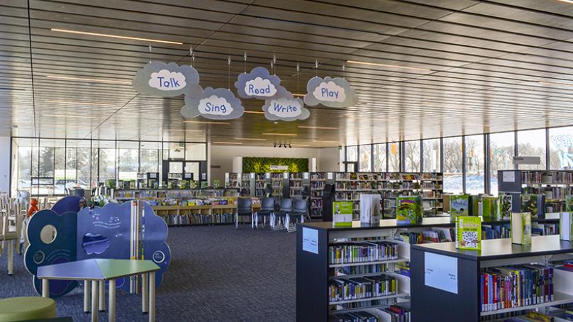 Interior of Transcona Library, with book stacks, tables and decorative signage