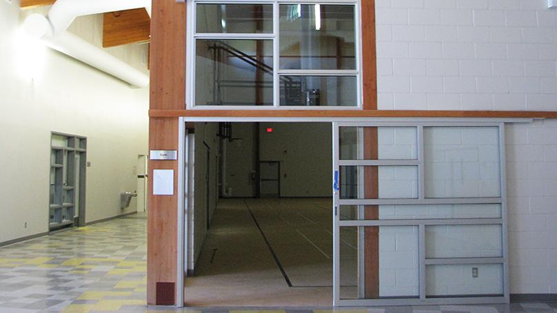 Hallway inside Sergeant Tommy Prince Place showing the glass doors to the gym