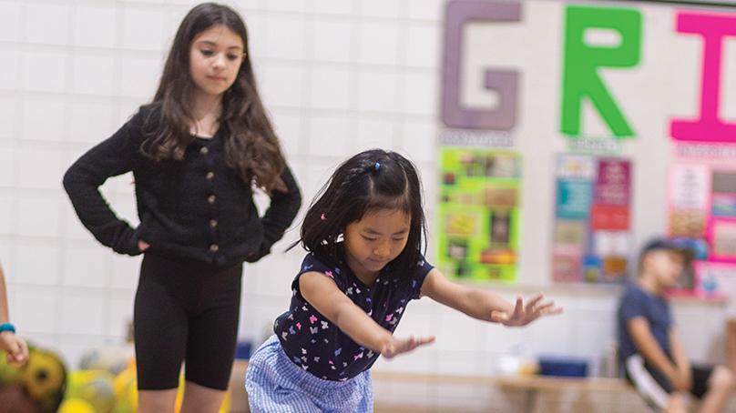 Two girls doing gymnastics in gymnasium