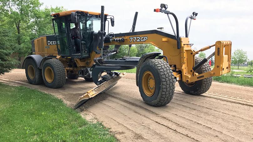 Grader equipment with a blade down on a gravel road