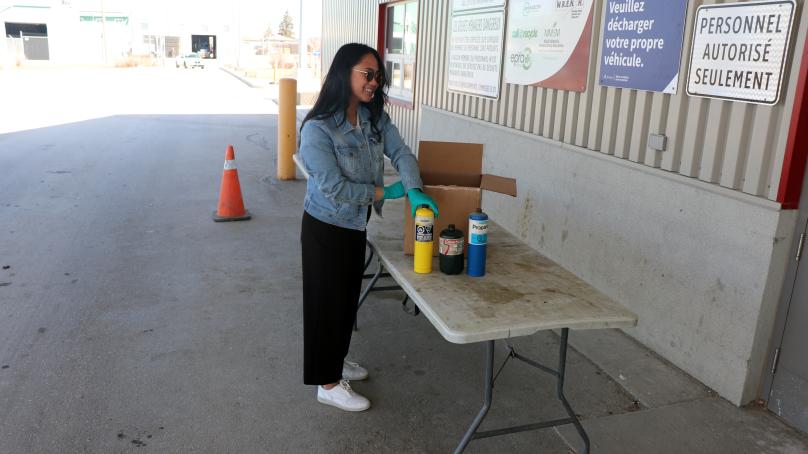 Woman recycling propane canisters at 4R Depot