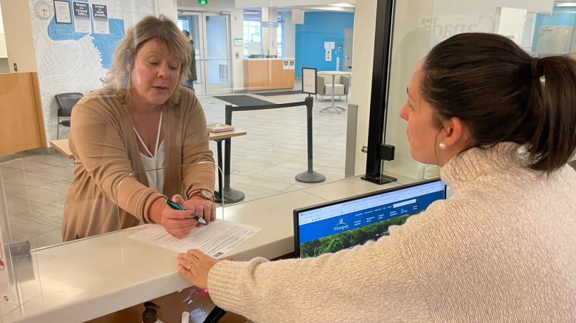 A woman receives help from a 311 customer service representative.