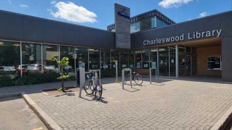 Entrance to Charleswood Library branch showing blue sky and bikes parked outside