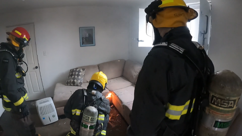 Firefighters setting a fire at the fire investigations training site