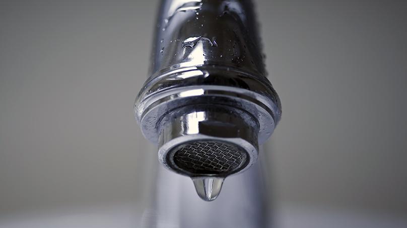 water drop coming out of a faucet