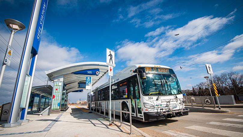 Winnipeg Transit bus stopped at a bus stop on the Southwest Rapid Transitway